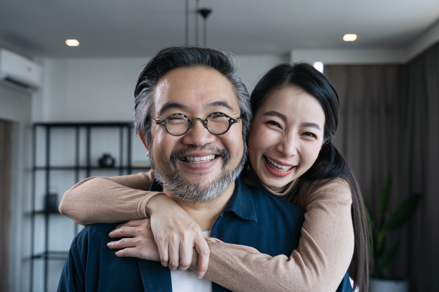 特寫拍攝中年亞洲夫婦微笑面對鏡頭並相互對視，家庭夫婦肖像。
